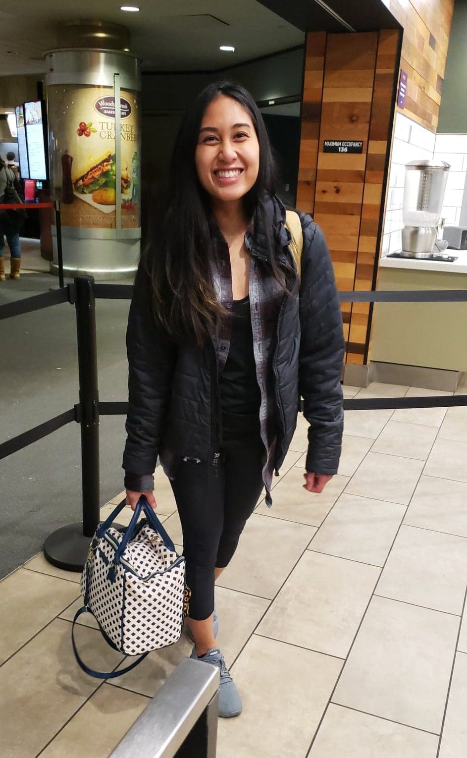 Christina carrying a lunchbox in the airport